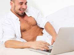 Attractive man chatting online with other gay men on webcam