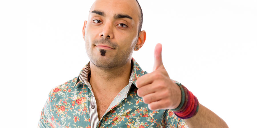 Gay man wearing a colourful shirt giving a thumbs up sign after coming out to family & friends